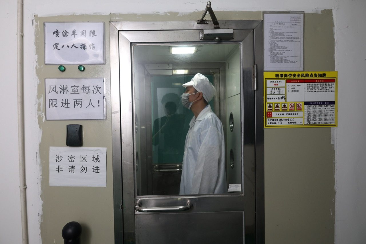 Gowned worker entering controlled cleanroom area