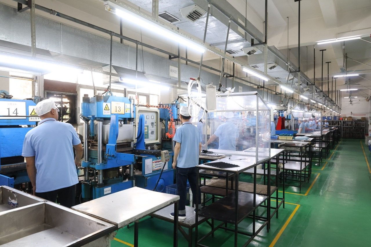 Production line of blue molding presses on factory floor