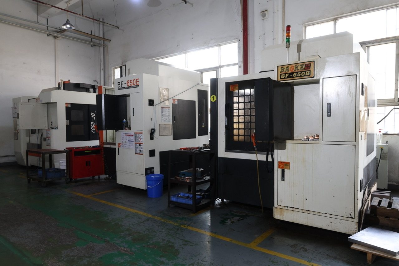 Row of CNC machining centers in tooling workshop